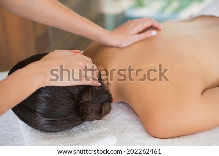 Brunette enjoying a massage lying on towel at the health spa