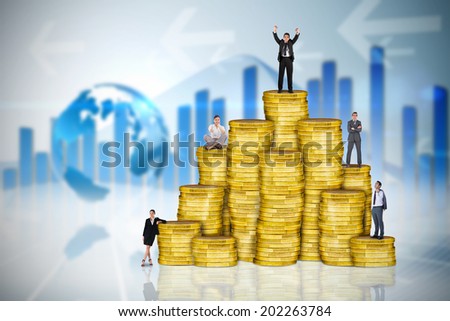 Composite image of business people on pile of coins against global business graphic in blue