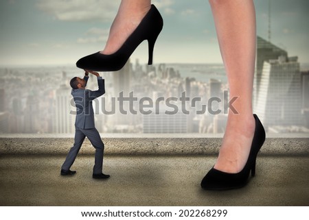Composite image of businesswoman stepping on tiny businessman against balcony overlooking city