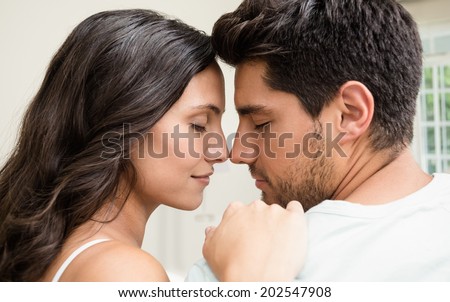 Attractive couple sitting face to face at home in bedroom