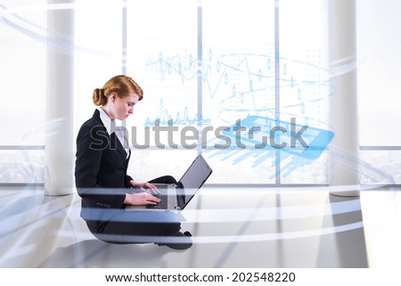 Redhead businesswoman using her laptop against bright room with columns