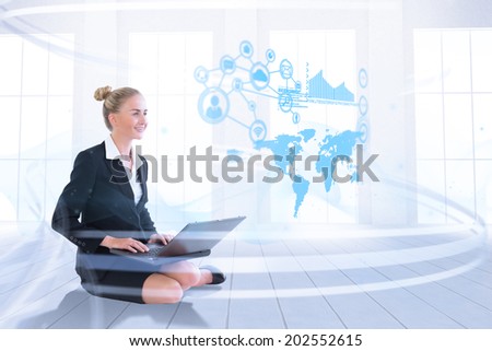 Businesswoman using laptop against bright room with windows