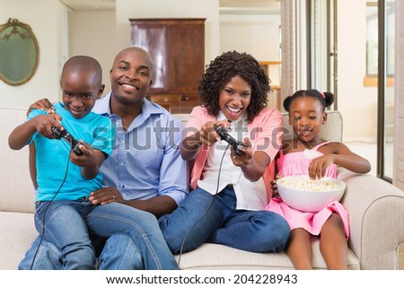 Happy family relaxing on the couch playing video games at home in the living room