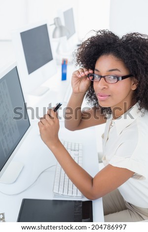 Smiling casual editor working at desk in her office