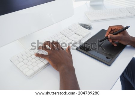 Designer sitting at his desk working with digitizer in his office