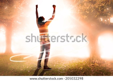 Cheering football fan against trees and meadow in the park
