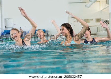 Female fitness class doing aqua aerobics in swimming pool at the leisure centre
