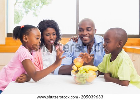 Happy family having fruit together at home in the kitchen