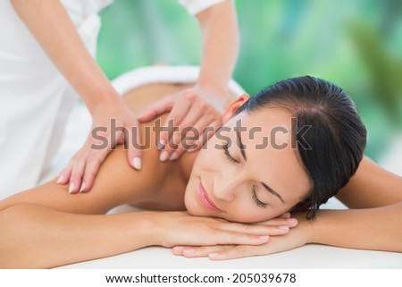 Beautiful brunette enjoying a back massage at a luxury spa