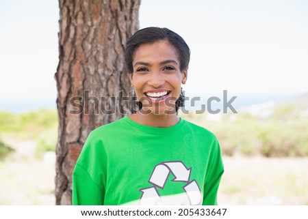 Pretty environmental activist smiling at camera on a sunny day in the countryside