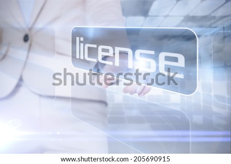 Businesswoman pointing to word license against futuristic grey room of squares