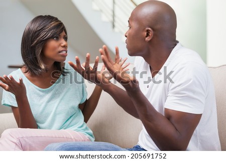 Angry couple having a dispute on sofa at home in the living room