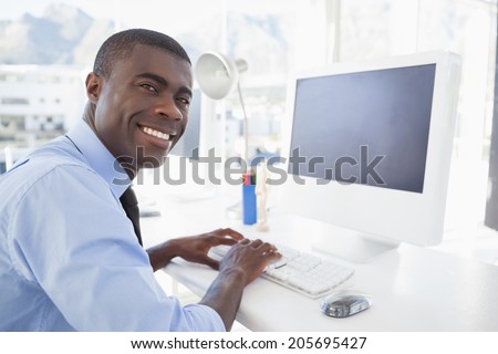 Happy businessman working at his desk in his office