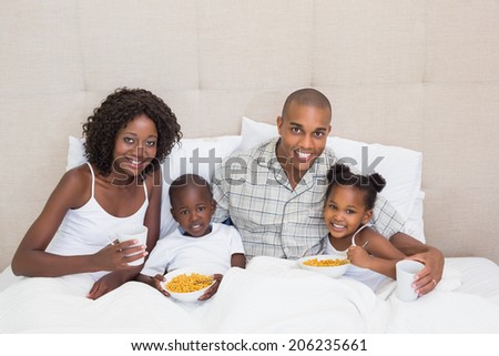 Happy family having breakfast in bed together in the morning at home in the bedroom