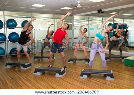 Fitness class doing step aerobics at the gym