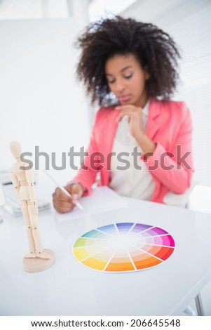 Casual graphic designer working at her desk sketching in her office