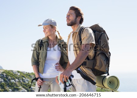 Hiking couple looking ahead at mountain summit on a sunny day