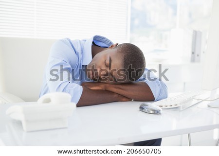 Tired businessman sleeping at his desk in his office