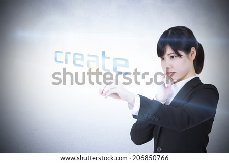 Businesswoman pointing to word create against white wall