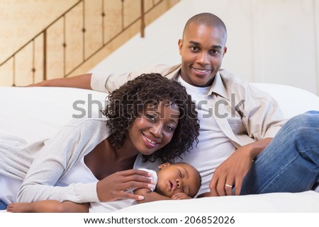 Adorable baby boy sleeping while being watched by parents at home in the living room
