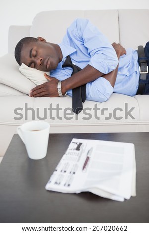 Tired businessman sleeping on the sofa at home in the living room