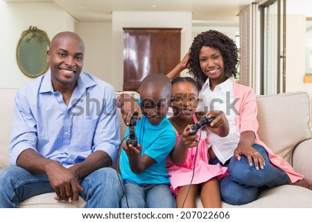 Happy family relaxing on the couch playing video games at home in the living room