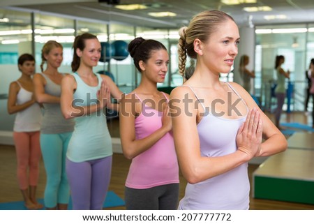 Yoga class in tree pose in fitness studio at the leisure center