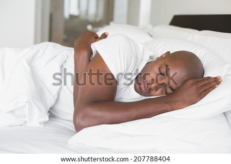 Peaceful man sleeping in bed at home in the bedroom