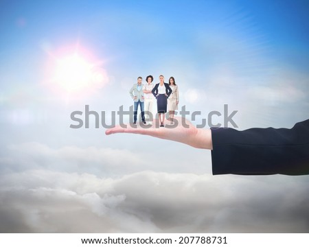 Business team looking at camera against blue sky with sunshine and clouds