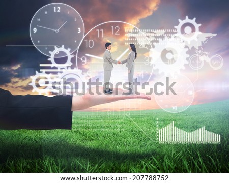 Side view of hand shaking trading partners against green field under orange sky