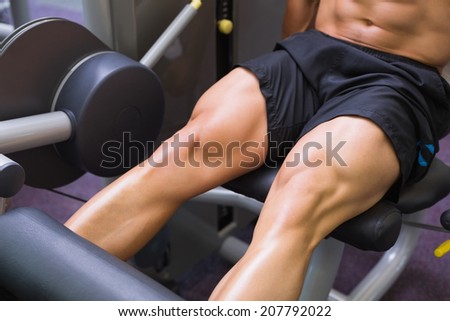 Close up mid section of muscular man doing a leg workout at the gym