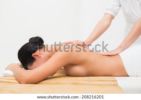 Beautiful brunette enjoying a back massage in the health spa