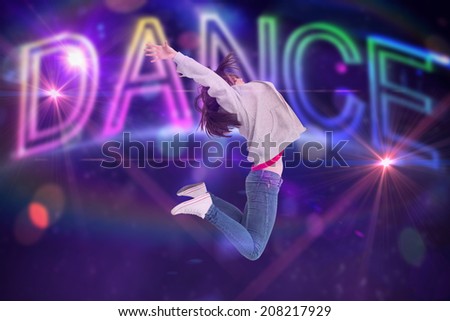 Cheerful young woman jumping against digitally generated colourful dance text