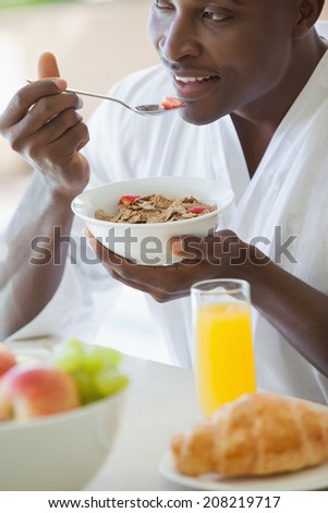 Happy man eating bowl of cereal outside on a sunny day