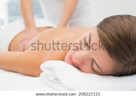 Close up of an attractive young woman receiving back massage at spa center