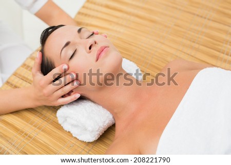 Peaceful brunette enjoying a head massage in the health spa