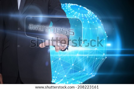 Businessman pointing to word awareness against glowing sphere on black background