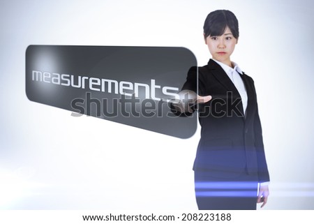 Businesswoman pointing to word measurements against white background with vignette