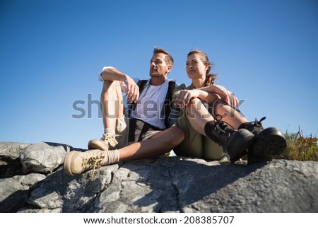Hiking couple looking out over mountain terrain on a sunny day