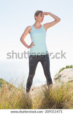 Fit blonde standing at summit on a sunny day
