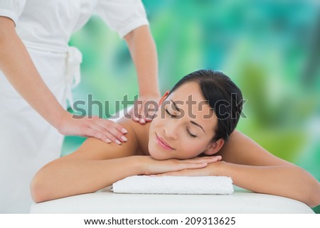 Beautiful brunette enjoying a back massage at a luxury spa