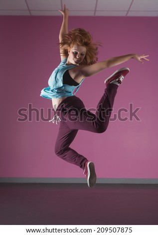 Pretty break dancer jumping up in the dance studio