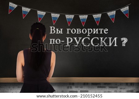 Standing businesswoman against blackboard on wall, Do you speak Russian?