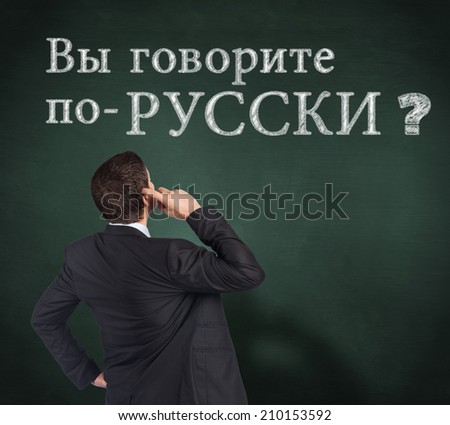 Thinking businessman scratching head against green chalkboard, Do you speak Greek?