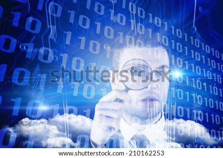 Businessman looking through magnifying glass against binary code on blue circuit board