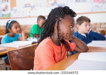 Cute pupils listening attentively in classroom at the elementary school
