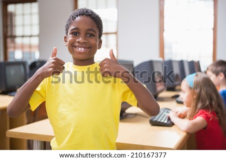 Cute pupil in computer class smiling at camera at the elementary school