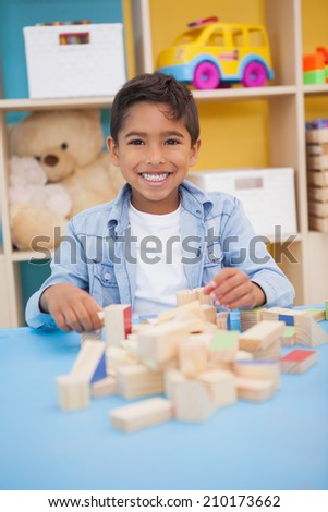 Cute little boy playing with building blocks at the nursery school