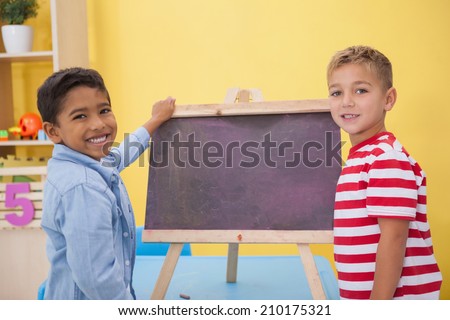 Cute little boys drawing on chalkboard at the nursery school