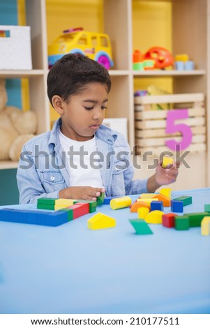 Cute little boy playing with building blocks at the nursery school